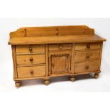 A late 19th/early 20th century large rustic kitchen dresser base, possibly sycamore and pine,