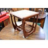 G-PLAN; a 1960s teak part nest of two tables, the largest inset with four tiles to the top,