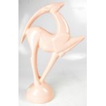 A large pink Art Deco style model of a leaping gazelle, to circular base, height 53cm.
