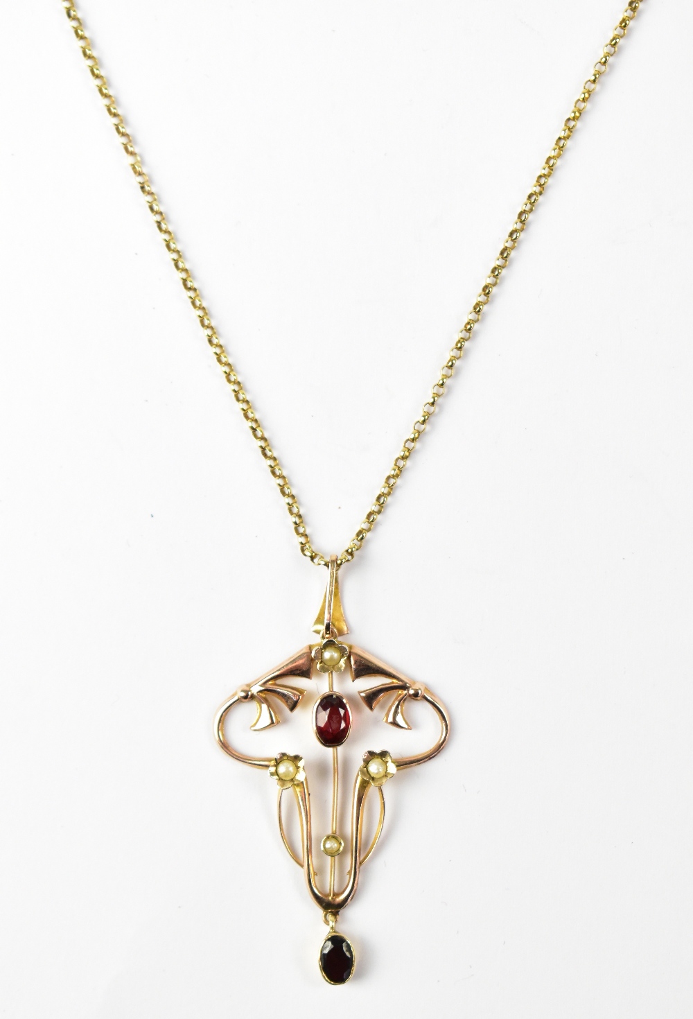 An Edwardian Art Nouveau style 9ct yellow gold pendant set with garnets and seed pearls, approx 2.