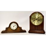 A modern wall-mounted clock with atlas finial to the top, moulded brass embellishments,