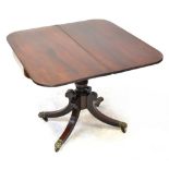 A reproduction Regency-style mahogany fold-over tea table raised on baluster turned central columns