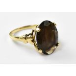 A 9ct gold fashion ring with oval cut transparent brown stone,