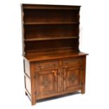 A modern reproduction oak dresser, on two-drawer, two-cabinet dresser base,