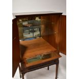 A reproduction mahogany-style cocktail cabinet, the interior with mirrored back,