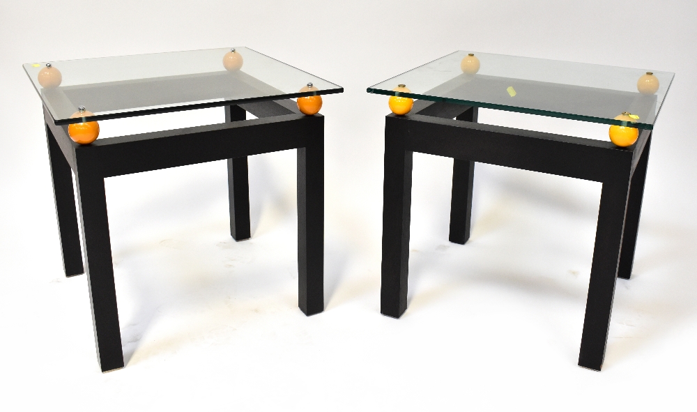 A pair of modern stylised glass top bedside/occasional/coffee tables,