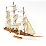 A scratch-built model sailing boat with three masts, rigged for full sail,