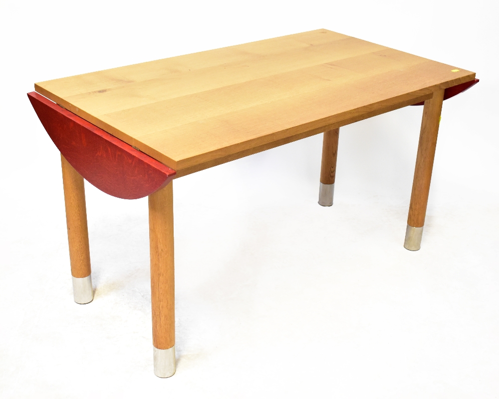 A modern stylised bespoke made oak table with an extending D-shaped small flap either end,