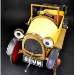 A child's pedal car, 'BRUM', painted red and yellow, 52 x 85 x 40cm.