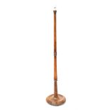 A stained pine standard lamp with tapering column to stepped circular support and bun feet,