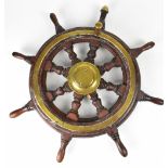 A brass bound wooden ship's wheel with turned wooden handles and brass handle, diameter 62cm.