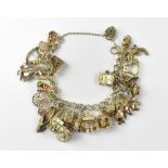 A hallmarked silver charm bracelet with approximately twenty-five silver charms to include