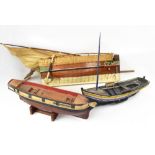 An early 20th century hand painted wooden model boat, with weighted hull, on associated stand,