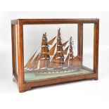 A late 19th century cased model of a tea clipper, with wooden sails,