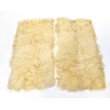 Two sheepskin rugs with blue material backing, each approx 170 x 84cm (2).
