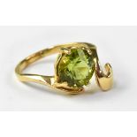 A contemporary 14ct gold dress ring, with claw set green stone, possibly peridot,