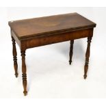 A late 19th century mahogany rectangular topped fold-over card table on turned tapering legs,