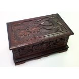 An early/mid-20th century Chinese carved wooden casket, the lid decorated with a dragon, width 31cm.