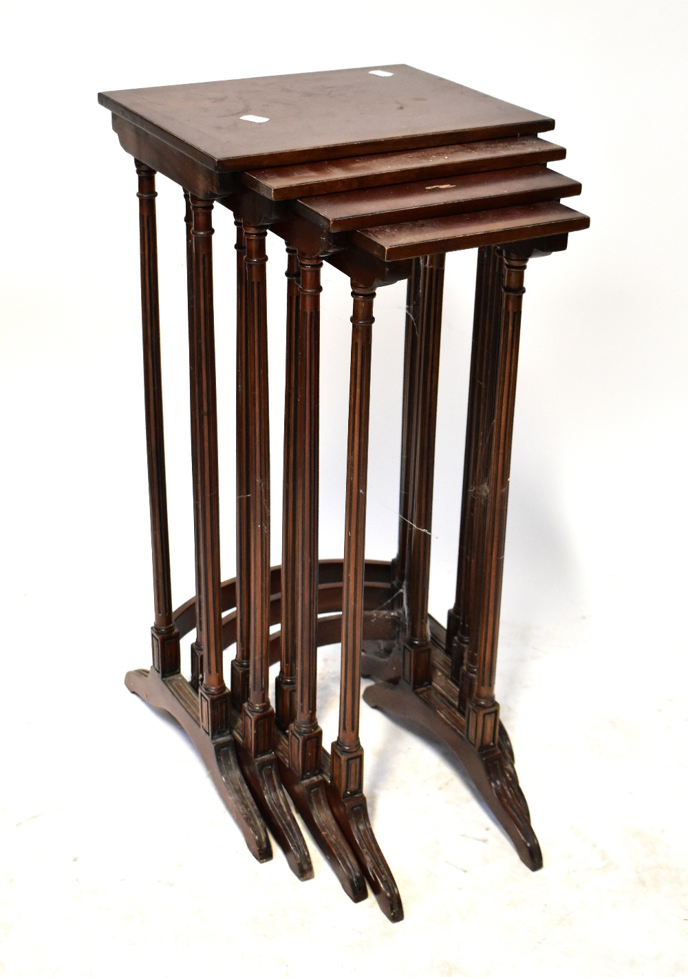 A reproduction nest of four tables raised on reeded supports, largest 71 x 35 x 26cm (af).