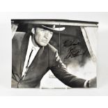 CLINT EASTWOOD; a black and white reproduced photograph of the mega, star bearing his signature, 25.