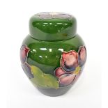 MOORCROFT; a small ginger jar with tube lined pansy design, on a green ground, height 11cm.