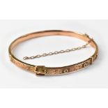 A 9ct gold belt and buckle style hinged bracelet,