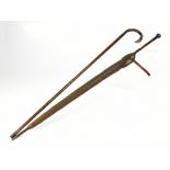 A silver topped bamboo-effect walking stick and a further silver topped bamboo-effect umbrella,