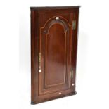 A George III mahogany wall-hanging corner cupboard with fielded and panelled strung door,