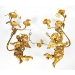 A pair of gilded cherubic three-branch wall sconces with ivy leaf decoration,