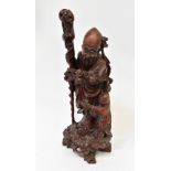 An early 19th century carved Oriental root wood figure of a sage with staff, with boy by his side,