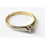 An 18ct diamond ring, the bezel set tiny diamond in a platinum mount, on an 18ct yellow gold shank,