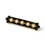 A 15ct gold mourning brooch with black enamel and a central line of five small seed pearls in gold