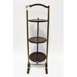 A mid-20th century mahogany-effect Bakelite and brass folding three-tier cake stand, height 91cm.