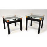 A pair of modern stylised glass top bedside/occasional/coffee tables,