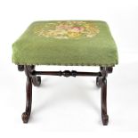 A Victorian mahogany X-framed footstool, with floral tapestry padded seat.