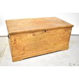 An early 20th century pine blanket box with hinged lid enclosing internal compartments,
