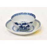 NANKING CARGO; a tea bowl and saucer decorated with a blue tree and fence pattern,