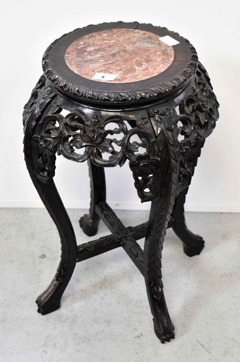 An Oriental carved hardwood jardinière stand, with rouge marble inset panel to the top,