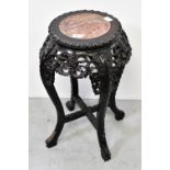 An Oriental carved hardwood jardinière stand, with rouge marble inset panel to the top,