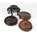 Four early 20th century Chinese mahogany hardwood vase stands, height of tallest 9cm,