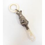 A George VI hallmarked silver mother of pearl mounted baby's rattle in the form of a seated possum,