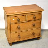 An early 20th century pine chest of two short over two long drawers, raised on turned feet,