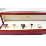 A jewellery box containing five silver ladies' dress rings, each set with semiprecious stone,