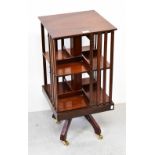 A mahogany revolving bookcase raised on quadripartite base to castors, 61 x 38 x 38cm.