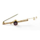 A 9ct gold ladder-style bar brooch with central cut amethyst in bezel set mount,