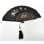 An early 20th century black paper fan with silver painting of peonies, cherry blossom,