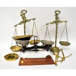 Five examples of vintage scales to include three brass beam scales with brass pans and decorative