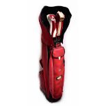 A vintage red golf bag containing a quantity of John Letters golf clubs.
