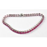 A silver articulated tennis bracelet set with rubies.