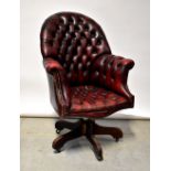 A reproduction oxblood leather button pressed office revolving armchair,